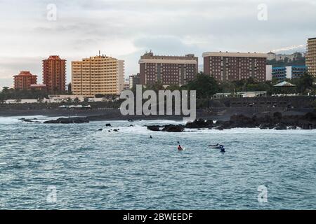 Surfer im Meer am Playa Jardin im Touristenort Puerto de la Cruz im Norden Teneriffas. Stockfoto