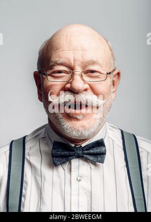 Lächelnder älterer Mann in Fliege und Brille Stockfoto