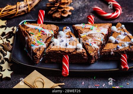 Weihnachtsbaum Brownies mit Zuckerrohr und Glasur, dunkler Hintergrund. Weihnachtsessen Konzept. Stockfoto