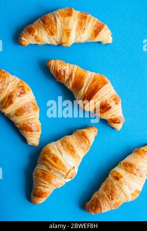 Gruppe von Croissants frisch gebacken auf blauem Hintergrund. Draufsicht. Stockfoto