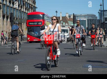 Junge Radfahrer, die Ende Mai 2020 während der Coronavirus-Pandemie eine Kreuzung am Parliament Square in Westminster im Zentrum von London überquerten Stockfoto
