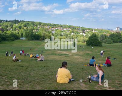 Menschen, die die Sonne auf Hampstead Heath in Nord-London während der Lockdown-Phase der 2020 Coronavirus-Pandemie genießen Stockfoto