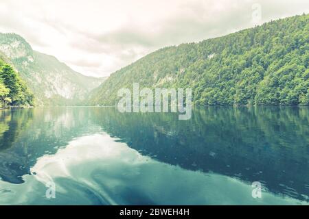 Landschaft mit Morgennebel im Waldsee. Bergseenlandschaft, nebeliger grüner Wald unter Wolken. Ruhige Natur, alpine Landschaft Stockfoto