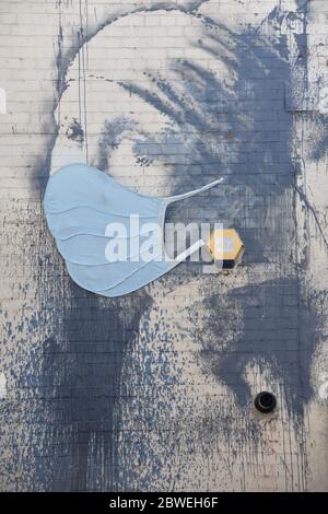 Banksy Graffiti das Mädchen mit dem durchbohrten Trommelfell mit blauer Gesichtsmaske (Covid-19). Albion Dockyard, Hanover Place, Bristol Stockfoto