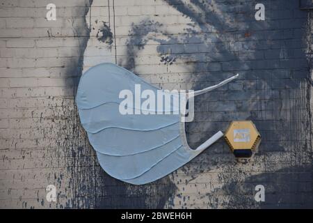 Banksy Graffiti das Mädchen mit dem durchbohrten Trommelfell mit blauer Gesichtsmaske (Covid-19). Albion Dockyard, Hanover Place, Bristol Stockfoto