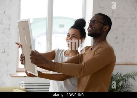 Paar hängenden Bilderrahmen während Umzug Tag zu Hause Stockfoto