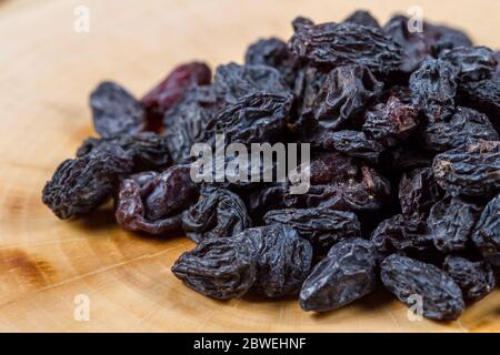 Usbekische blaue Rosinen auf einem Holztisch. Backzutaten. Gesundes Essen. Stockfoto