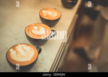 Auf dem Tisch liegen wunderschöne Latte Art Kaffees. Stockfoto