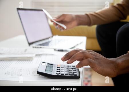 African man berechnet Kosten mit Rechner Nahaufnahme Bild Stockfoto