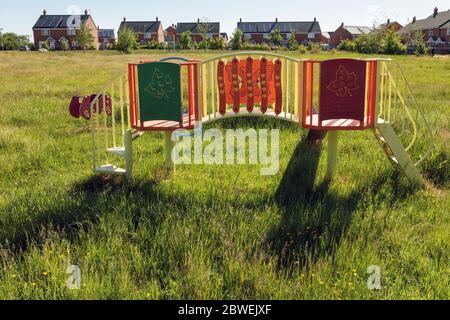 Langes Gras auf einem geschlossenen Kinderspielplatz nach 10 Wochen der Sperrung des Coronavirus, Ashbourne, Derbyshire, Juni 2020 Stockfoto