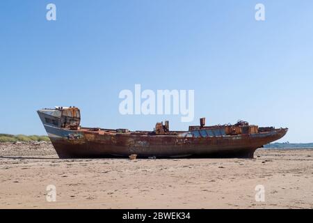 YELLAND, NORTH DEVON, Großbritannien - MAI 28 2020: Abgebrochenes Schiffswrack am Sandstrand. Rostender Rumpf am Strand. Profil. Stockfoto