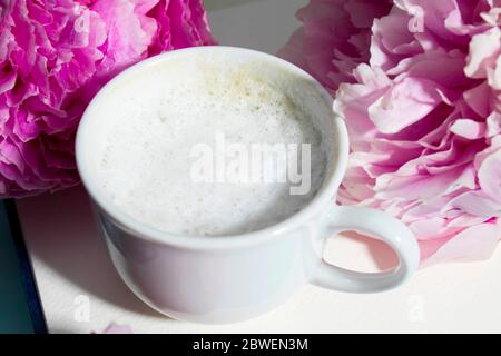 Drei frisch blühende rosa Pfingstrosen liegen auf einem weißen offenen Notizbuch. Platz für Text. Liste „To Do“. Bildungskonzept. Liebesbrief Stockfoto