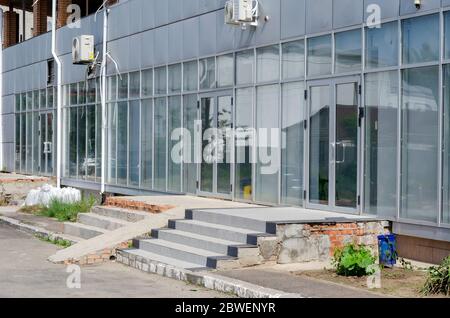 Fassade eines neuen Geschäftsgebäudes im Bau. Eine Reihe von grauen Räumen aus Glas und Metall für Geschäfte oder Büros. Bauindustrie. Re Stockfoto