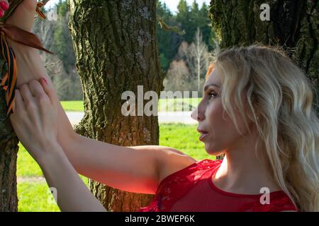 Porträt einer blonden reifen Frau, die sich an einem sonnigen Sommertag in der Natur entspannt Stockfoto