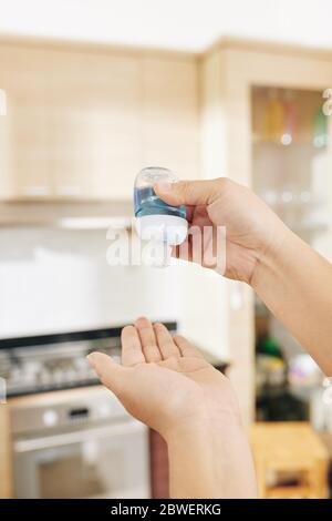 Nahaufnahme der Frau, die nach dem Berühren von Oberflächen antibakterielles Handgel aufwendet Stockfoto