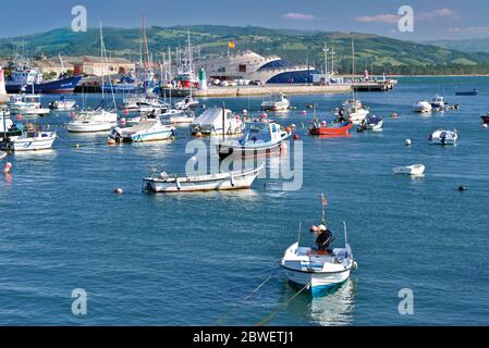 Fischerboote ankern im Hafen und in der ruhigen Bucht von Santona mit Mirador de las Marismas im Hintergrund Stockfoto