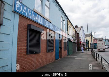 Sheffield UK – April 09 2020: Eine eineinreisende Frau geht während der Sperrung des Coronavirus Covid-19 an der Staniforth Road durch die leeren Straßen von Darnall Stockfoto