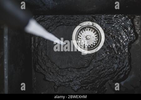 Wasser fließt durch das Spülbecken Stockfoto