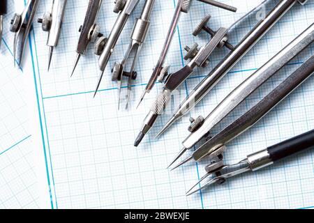 Satz alter Zeichenwerkzeuge auf Hintergrund mit Diagrammpapier Stockfoto