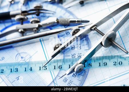 Satz alter Zeichenwerkzeuge auf Hintergrund mit Diagrammpapier Stockfoto