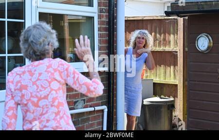 Rustington West Sussex UK 1. Juni 2020 - eine emotionale Jennie Dack (rechts) trifft sich mit ihrer Mutter Jean Russell, die in Rustington West Sussex bei Littlehampton zum ersten Mal seit Beginn der Blockierung im März während der COVID-19-Pandemie lebt.: Credit Simon Dack / Alamy Live News Stockfoto