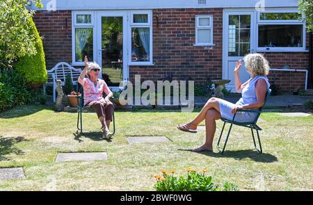 Rustington West Sussex UK 1. Juni 2020 - Jean Russell (links) aus Rustington bei Littlehampton plaudert und scherzt mit ihrer Tochter Jennie im Garten, nachdem sie sich zum ersten Mal seit der Sperrung im März während der COVID-19-Pandemie wiederfand.: Credit Simon Dack / Alamy Live News Stockfoto