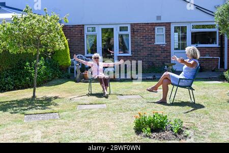 Rustington West Sussex UK 1. Juni 2020 - Jean Russell (links) aus Rustington bei Littlehampton plaudert und scherzt mit ihrer Tochter Jennie im Garten, nachdem sie sich zum ersten Mal seit der Sperrung im März während der COVID-19-Pandemie wiederfand.: Credit Simon Dack / Alamy Live News Stockfoto