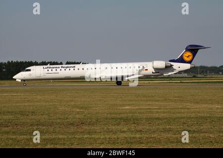 Deutsche Lufthansa CityLine Bombardier CRJ900 mit Registrierung D-ACKJ rollt auf Rollweg V des Amsterdamer Flughafens Schiphol. Stockfoto