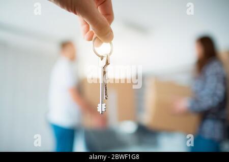 Die Schlüssel in den Händen der Wohnung Nahaufnahme. Vor dem Hintergrund einer jungen Sieben zieht in ein neues Haus Stockfoto