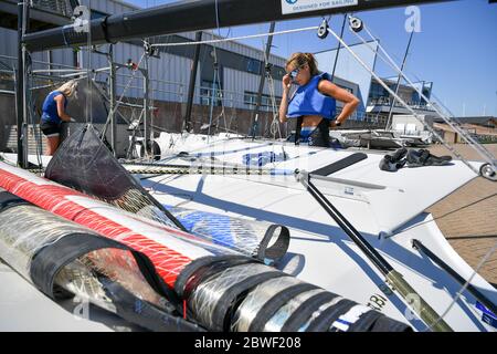 Die 2020 Athleten Saskia Tidey, links, und Charlotte Dobson, rechts, bereiten ihre 49er FX für eine Trainingseinheit vor, da die Mitglieder des Teams GB bei Weymouth und der Portland National Sailing Academy paarweise wieder auf dem Wasser trainieren, da die Lockdown-Beschränkungen in England lockern. Stockfoto