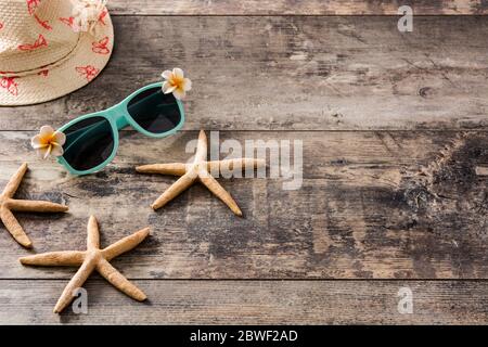 Sunglasses,starfish and summer hat on wooden background Stockfoto