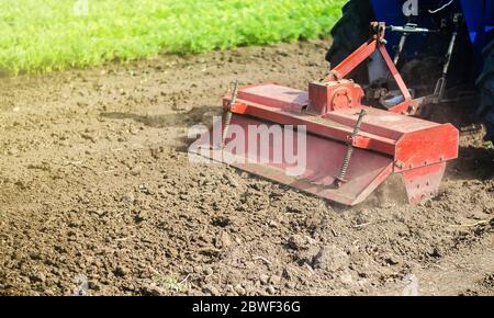 Traktor mit Fräsmaschine löst, mahlt und mischt gemahlen. Schleifen und lockern von Boden, Entfernen von Pflanzen und Wurzeln aus der vergangenen Ernte. Feldvorbereitung Stockfoto