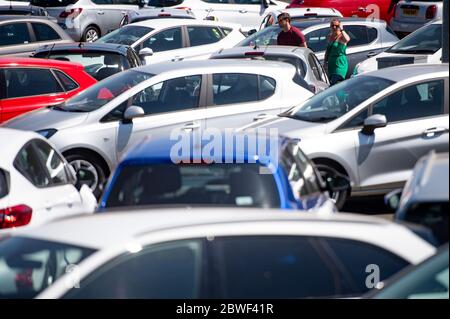 Die Menschen sehen Autos auf dem Vorplatz des Motorpoint Showrooms in Oldbury, West Midlands, als Autoausstellräume, die zum ersten Mal seit der Sperrung geöffnet werden, als Teil einer breiteren Lockerung der Beschränkungen in England. Stockfoto