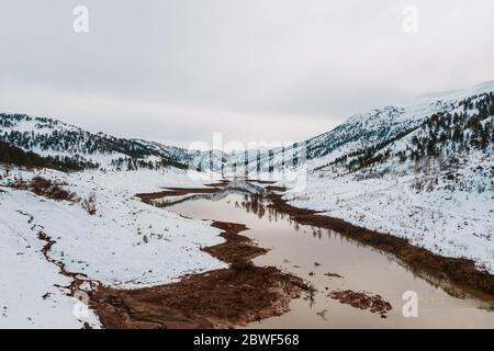 Luftaufnahme von schneebedeckten Bergen und Wäldern rund um den schönen See. Rime Eis und Raureif bedeckt Bäume, Felsen und Land in der Nähe von Haim, Konya, Türkei Stockfoto