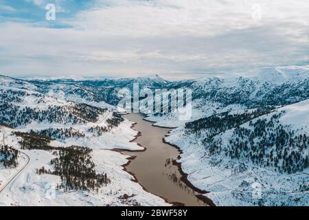 Luftaufnahme von schneebedeckten Bergen und Wäldern rund um den schönen See. Rime Eis und Raureif bedeckt Bäume, Felsen und Land in der Nähe von Haim, Konya, Türkei Stockfoto