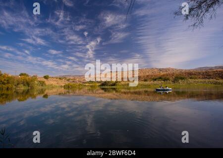 2 Personen rudern in einem Schlauchboot in einem natürlichen Wasserteich. Fotografiert im Naturschutzgebiet ein Afek, Israel Stockfoto