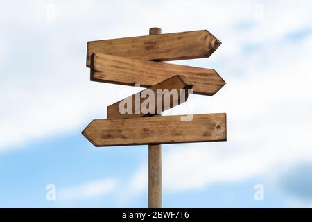 Holzschild auf blauem Himmel mit weißen Wolken isoliert. Richtungskonzept. Modell, Vorlage Stockfoto