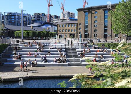 Menschen, die die Sonne am Granary Square am Kings Cross genießen, am letzten Tag des Monats Mai, als die Einschränkungen des Coronavirus gelockert werden, im Norden Londons, Großbritannien Stockfoto