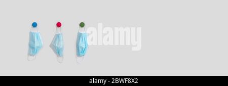 Familie schützende Medizin Maske auf Haken an der Wand des Hauses hängen. Persönliche Schutzausrüstung, Umweltverschmutzung, neues normales Konzept. Stockfoto