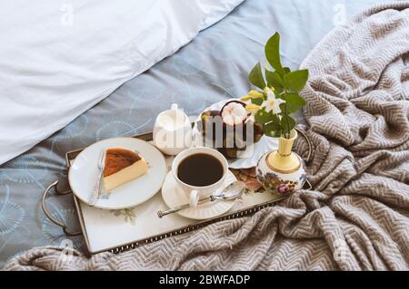 Frühstück im Bett Scheibe Cheesesescake und Obst mit einer Tasse Kaffee in einem Tablett Stockfoto