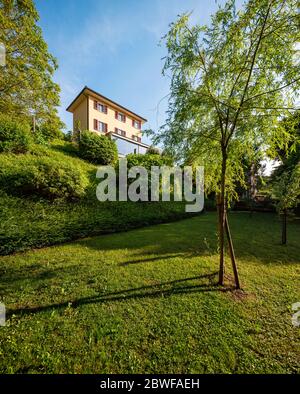 Schönes Haus mitten im Grünen mit einer modernen Stahlbetonverbindung und einem großen Fenster. Stockfoto