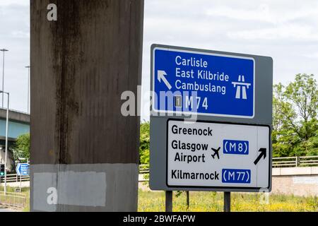 Verkehrsschild in Glasgow mit Zielen für die Autobahnen M74, M8 und M77. Stockfoto