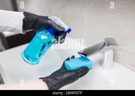 Weibliche Hände Reinigung Waschbecken Wasserhahn im Bad zu desinfizieren von Viren oder Bakterien und sauberen Kalk verhindern Infektion Stockfoto