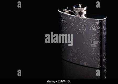 Prag, Tschechische Republik - 15. Mai 2020: Edelstahl-Flachflasche auf dem schwarzen Glastisch. Flasche für Alkohol. Lifestyle und Reisen. Stockfoto