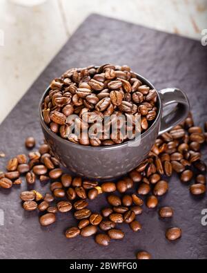 Kaffeetasse voll mit Kaffeebohnen. Stockfoto