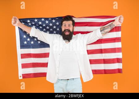 Visa freier Zugang. Visa-Antragsteller halten amerikanische Flagge. Glücklicher Mann bekam USA Visum gelben Hintergrund. Programm zur Befreiung von der Visumpflicht. Einwanderung und Staatsbürgerschaft. Juli. Wir feiern den Unabhängigkeitstag. Stockfoto