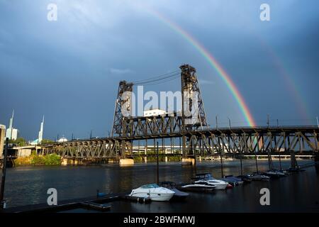 Doppelter Regenbogen über Stahl, mit stimmungsvollem Himmel, vertikale Hebebrücke über den Willamette River, Portland, Oregon, USA Stockfoto