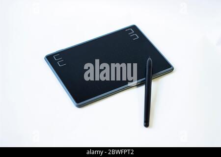 Grafiktablett mit Stift für Illustratoren, Maler und Designer auf weißem Hintergrund. Grafiktablett, Stift und schwarzer Handschuh für Illustratoren und Design Stockfoto