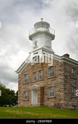 Sturmwolken nähern sich dem Leuchtturm von Great Captain Island mit seiner einzigartigen Steinarchitektur in Greenwich, Connecticut. Stockfoto