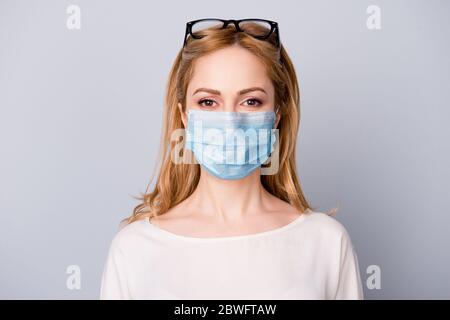 Nahaufnahme Porträt von ihr sie schön attraktive Inhalte ernst blonde Mädchen trägt Brille medizinische Maske Laser-Ansicht Korrektur isoliert über grau Stockfoto